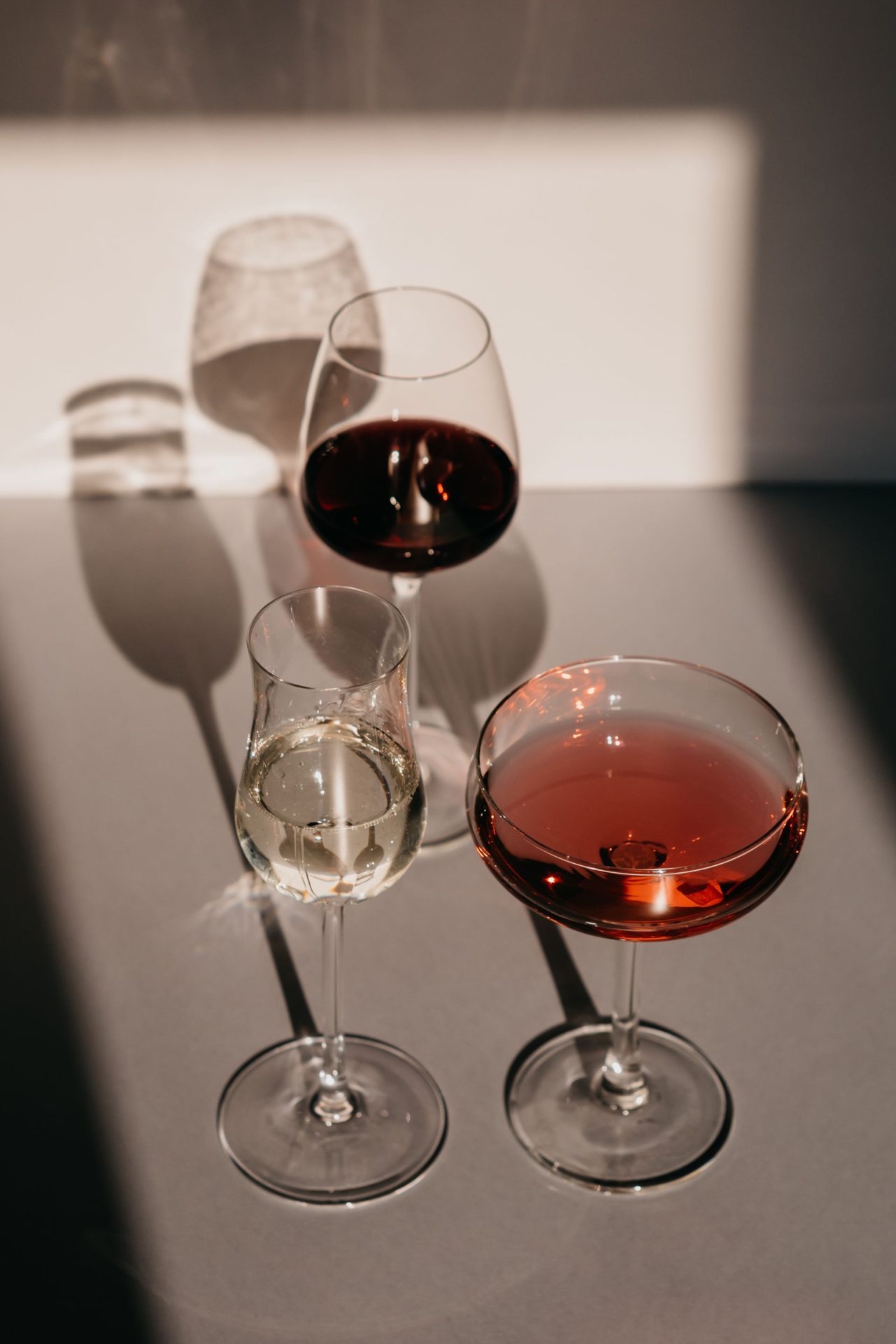 Calici di vino bianco, rosato e rosso nella luce
